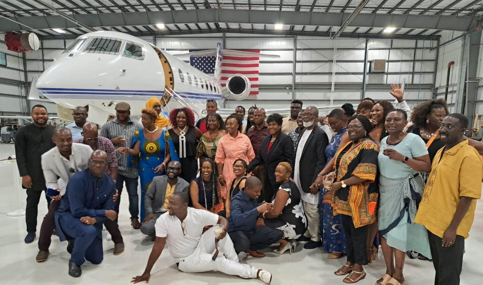 Group of people posing in front of a jet